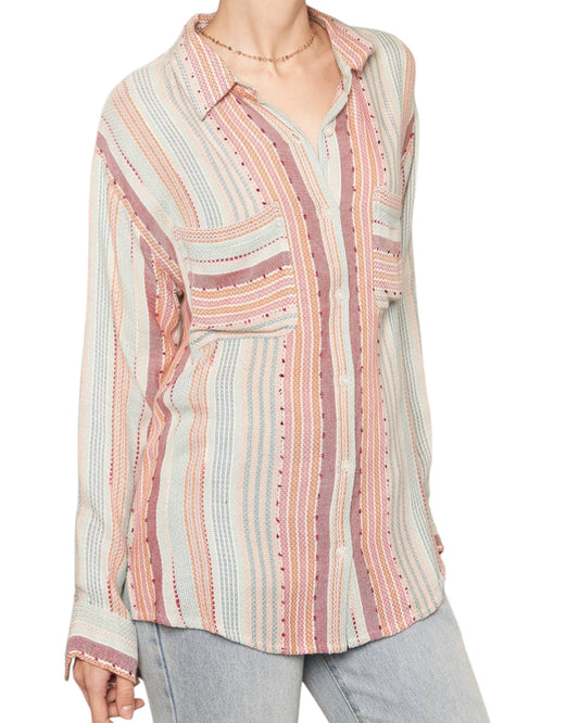 Multicolored striped shirt worn by a person on a white background