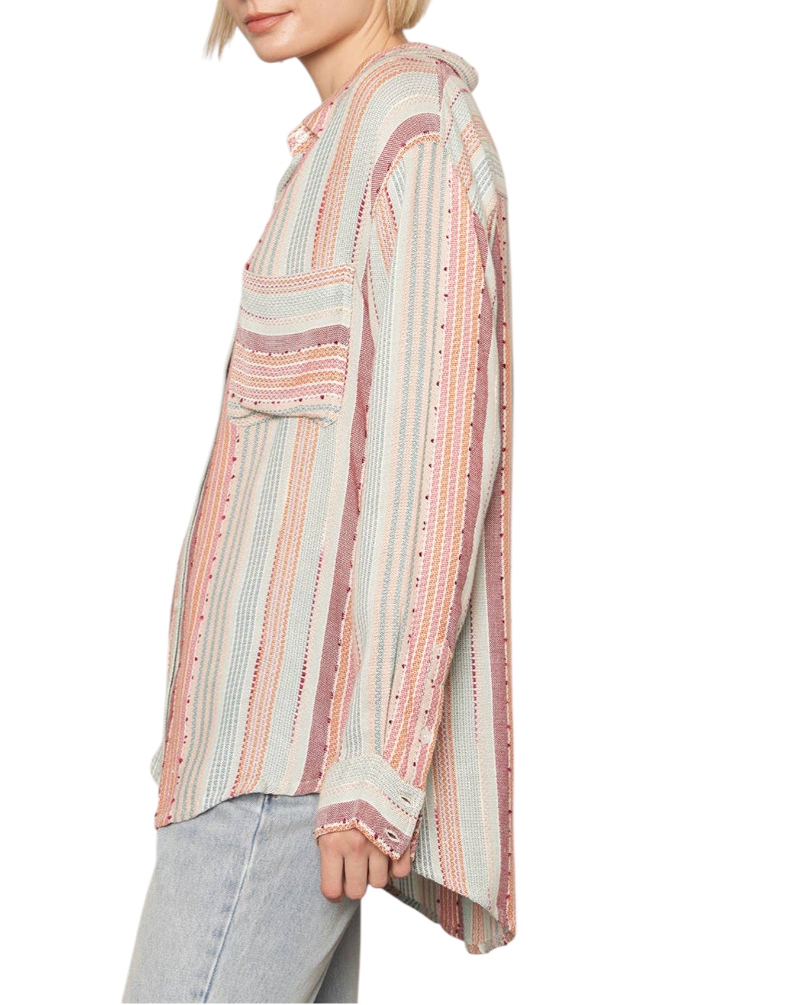 Woman wearing a long-sleeve, patterned shirt with a neutral background