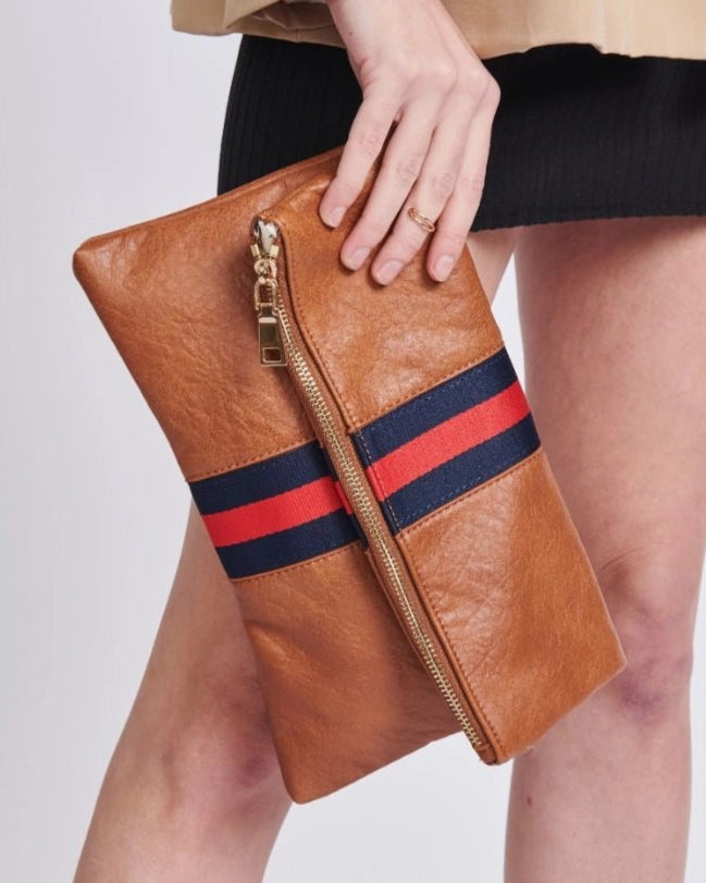 Brown vegan leather fold over clutch bag with sporty navy and red stripe, zipper and gold strap.
