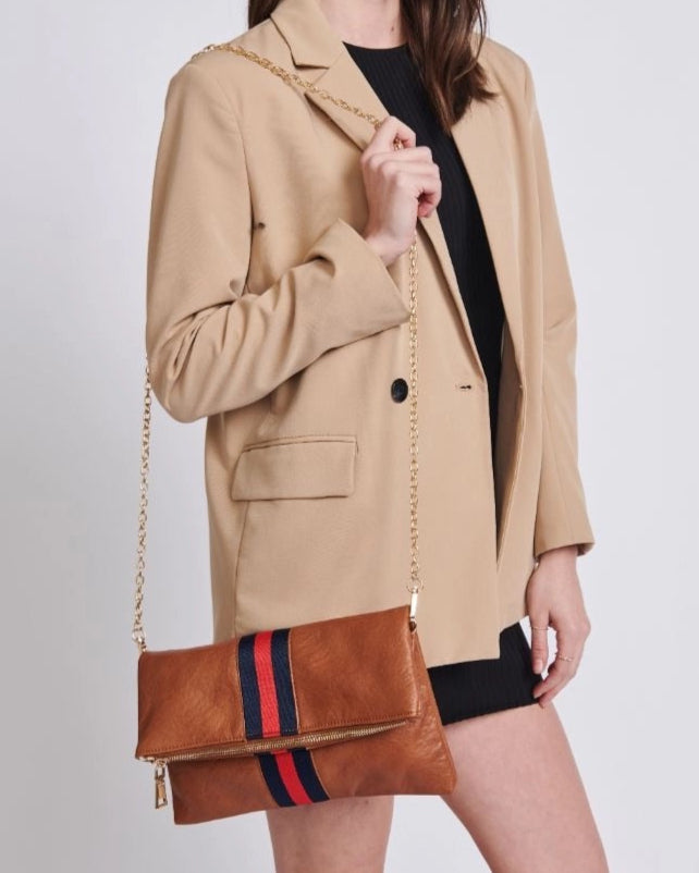 Brown vegan leather fold over clutch bag with sporty navy and red stripe, zipper and gold strap.