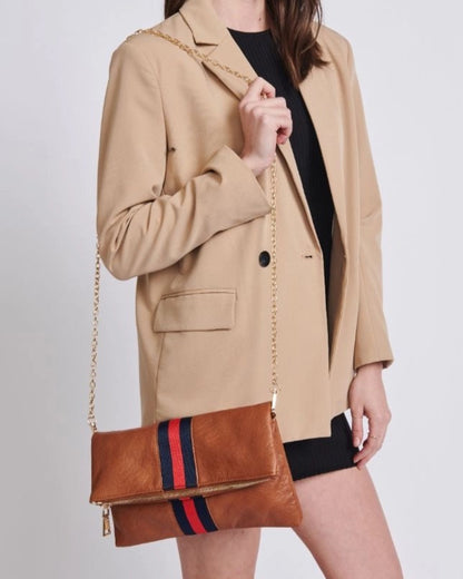 Brown vegan leather fold over clutch bag with sporty navy and red stripe, zipper and gold strap.