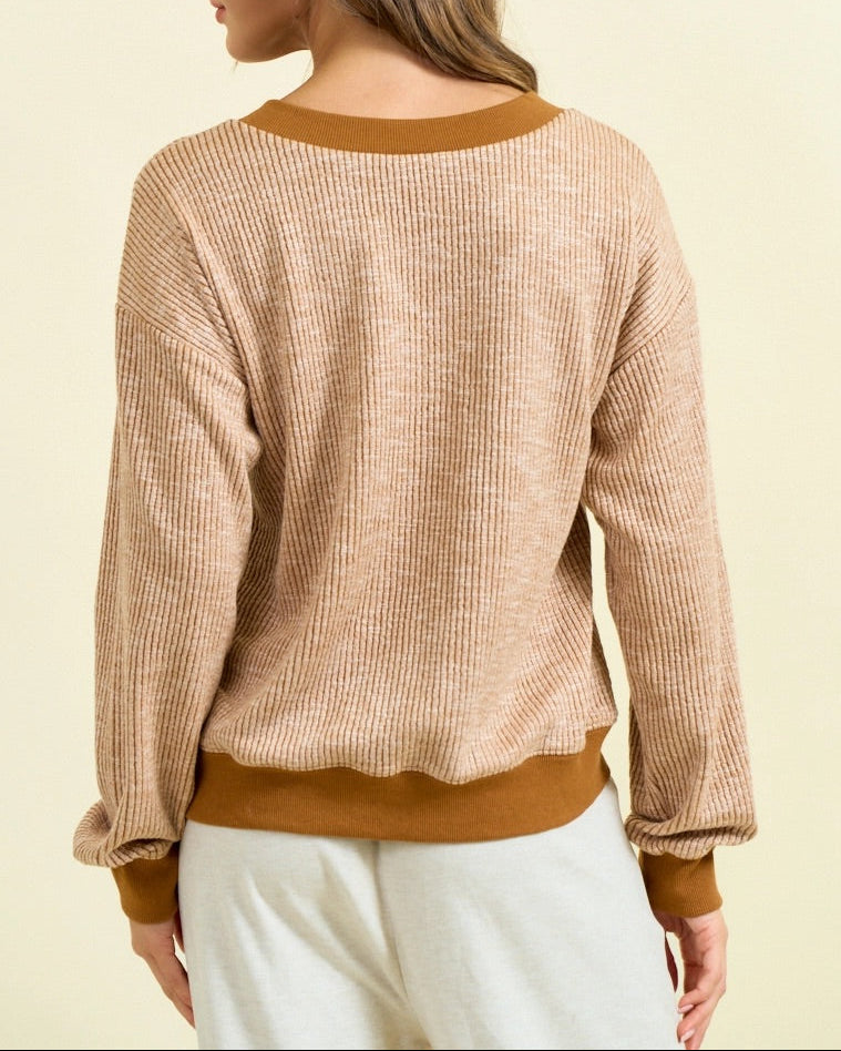 Camel ribbed V-neck pullover with contrast trim, vertical texture, and oversized fit.