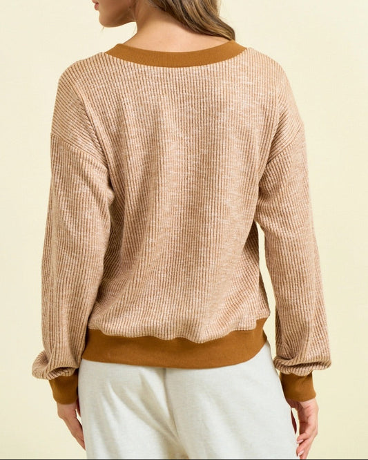 Camel ribbed V-neck pullover with contrast trim, vertical texture, and oversized fit.