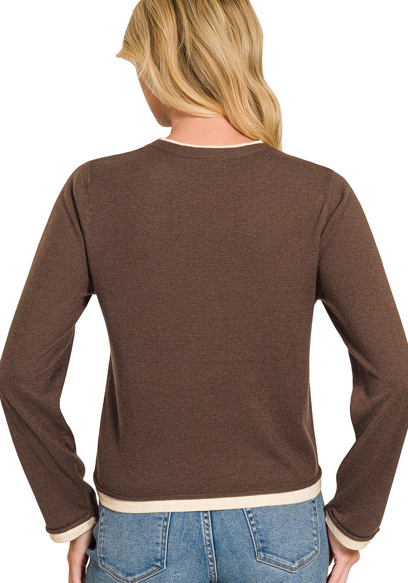 A woman shown from the back wearing a brown long-sleeve knit top with contrasting cream ribbed trim at the crew neck, cuffs, and hem, paired with blue jeans on a white background.