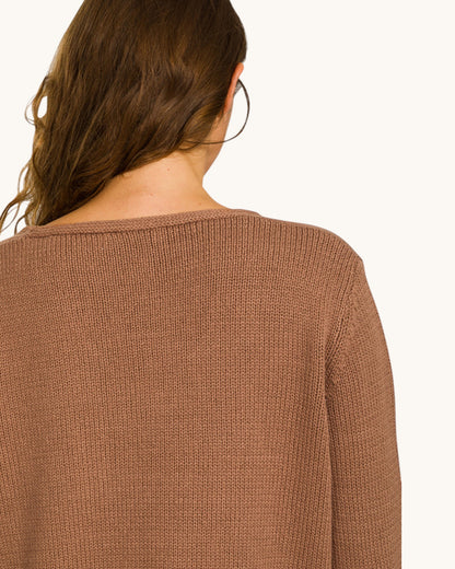 Brown sweater worn by a person on a white background.
