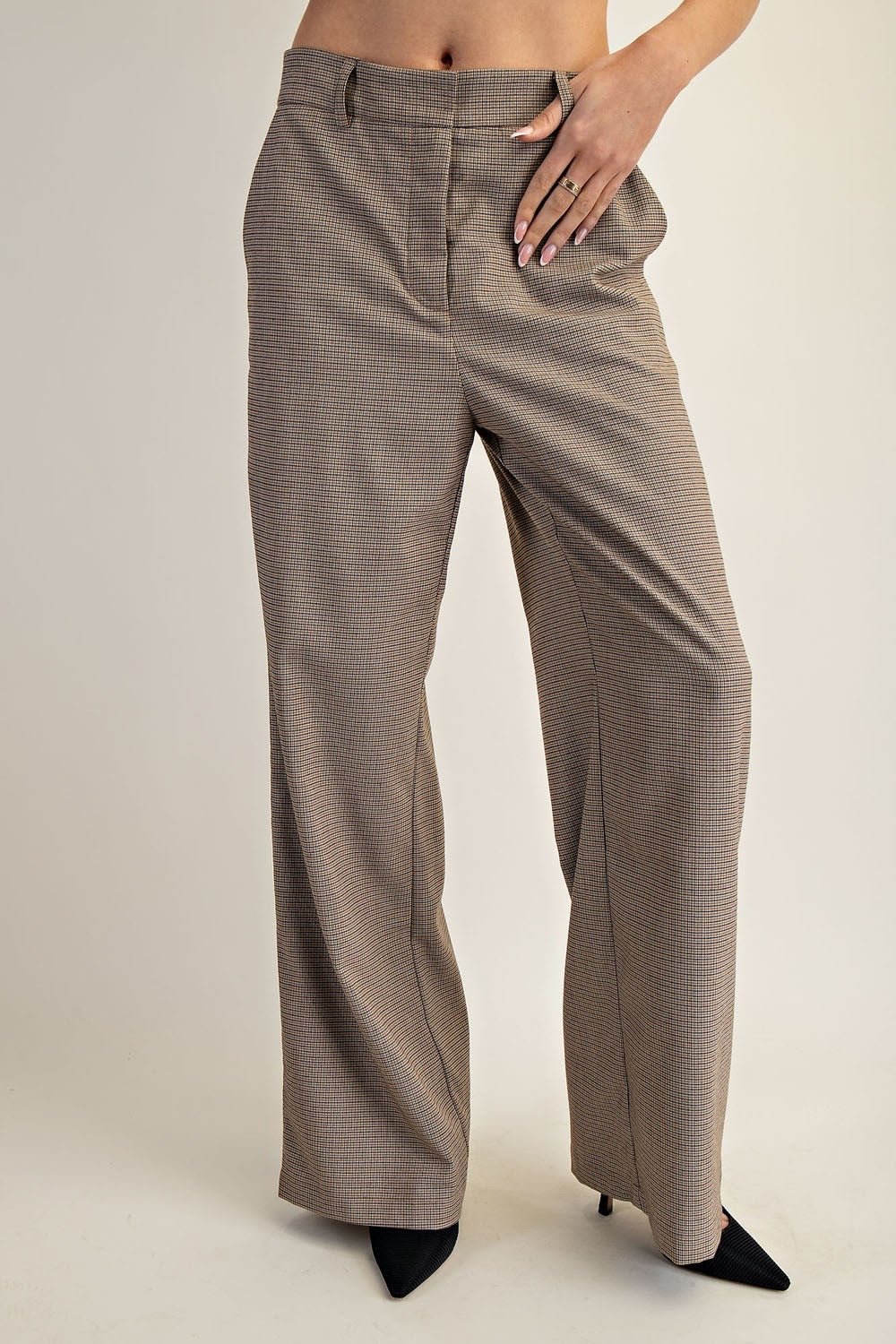 Brown checkered pants worn by a person on a plain background.