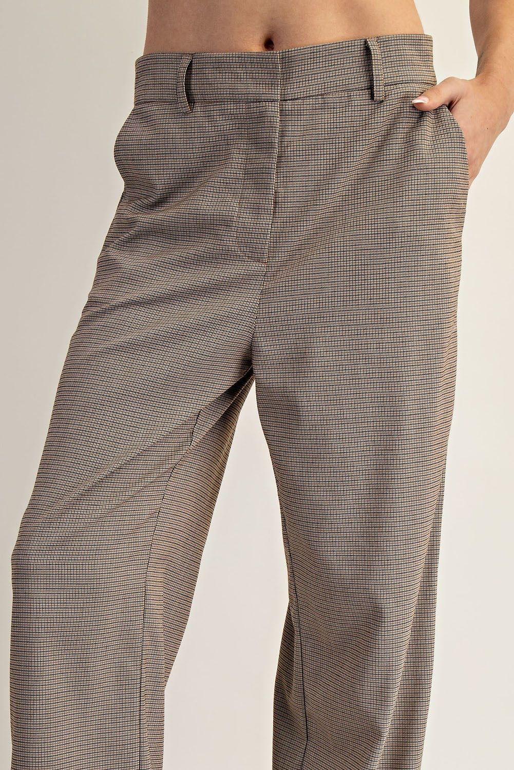 Brown checkered pants worn by a person on a plain background.