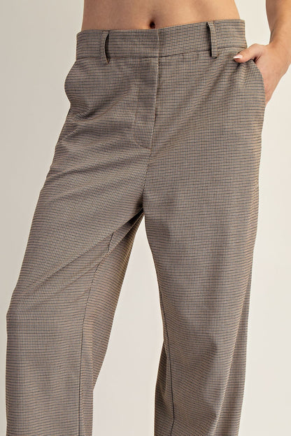 Brown checkered pants worn by a person on a plain background.