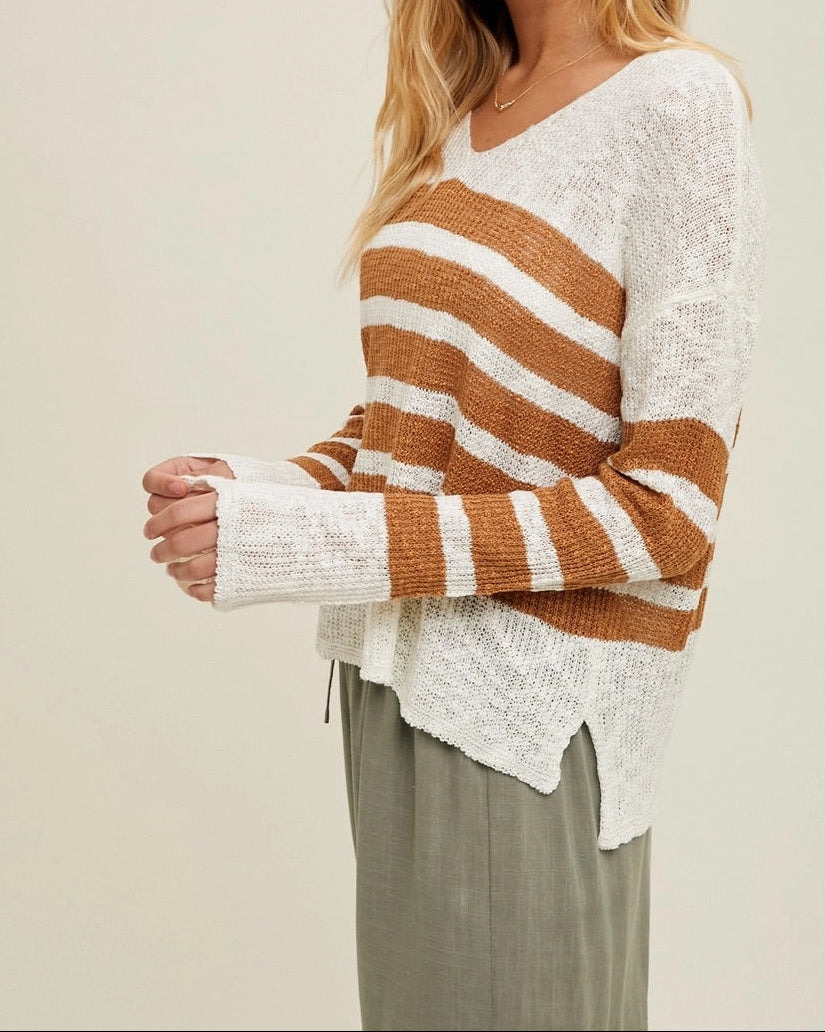 Woman wearing a striped sweater with a plain background.