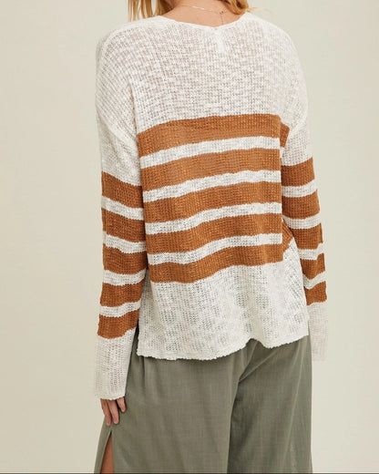 Woman wearing a white and brown striped sweater against a beige background