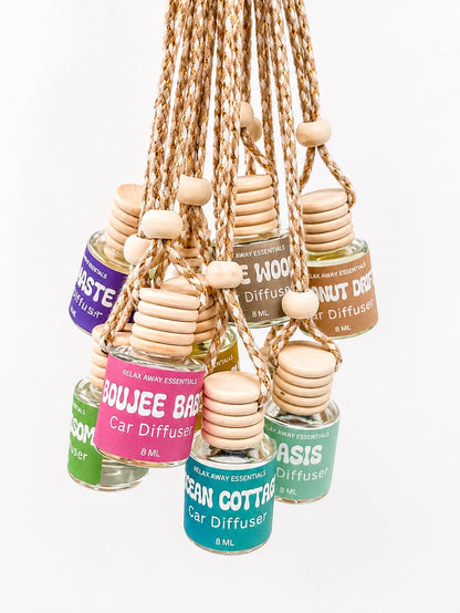 Collection of car diffuser bottles with wooden tablets on a white background.