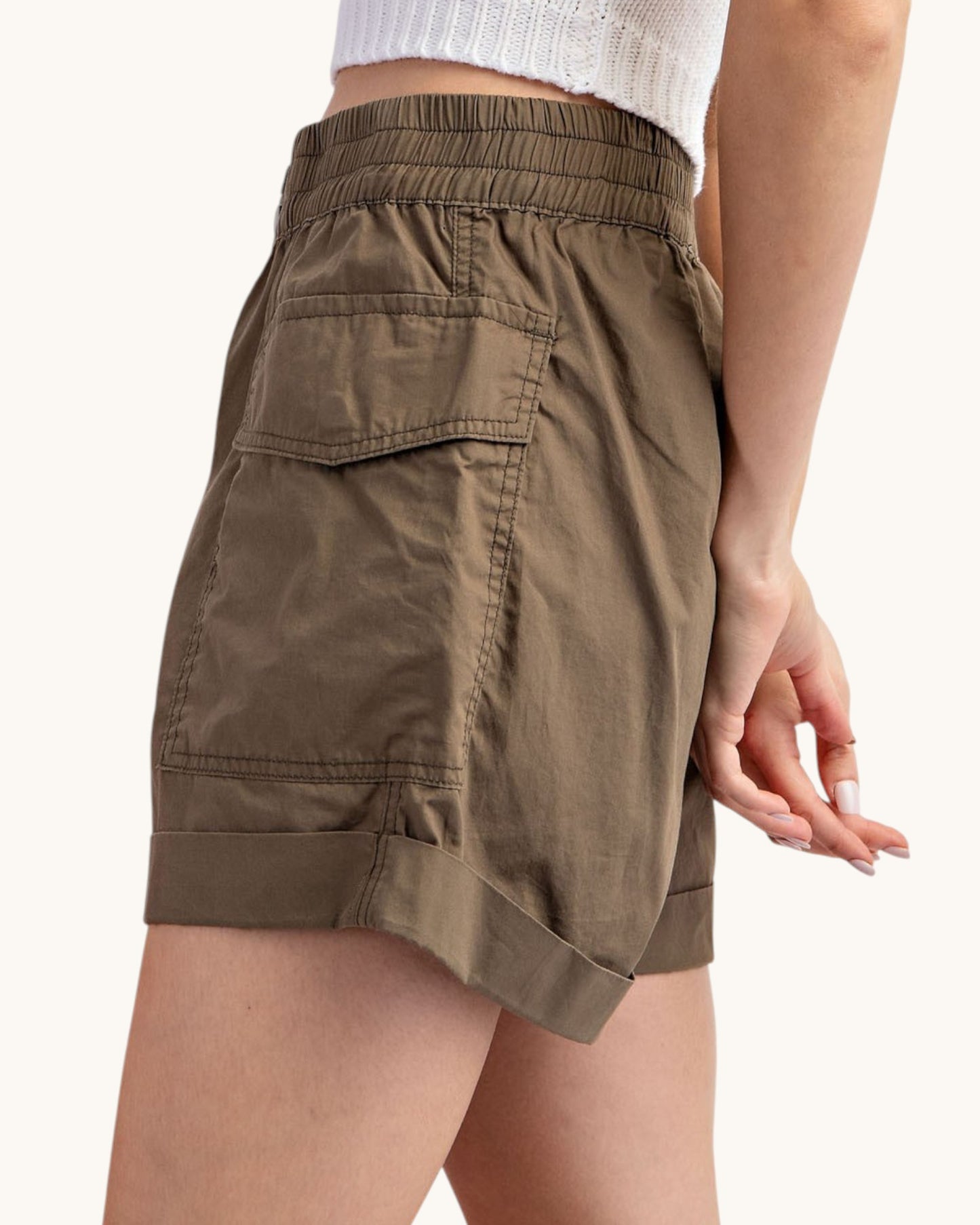Olive cargo shorts worn by a person on a white background.