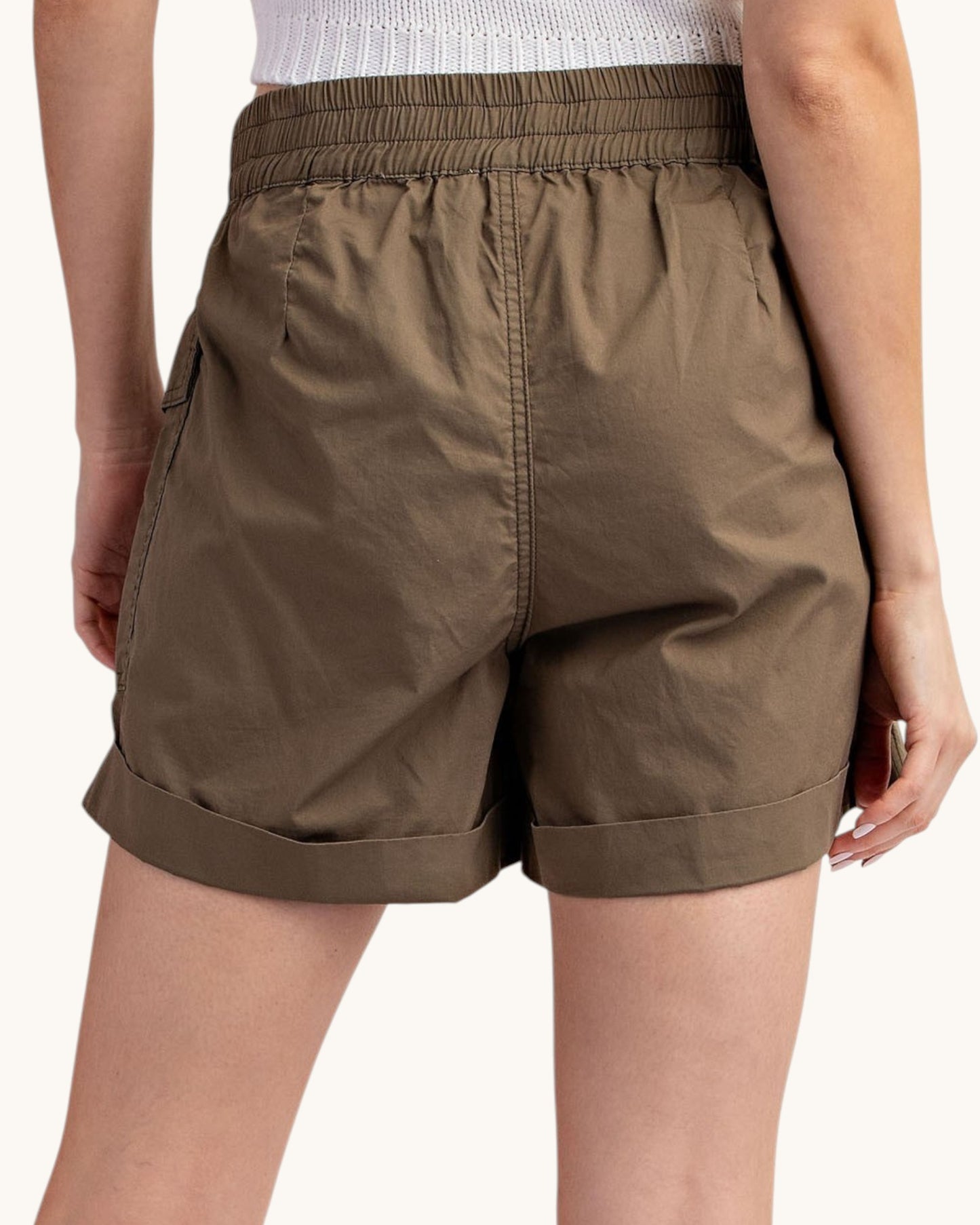 Olive cargo shorts worn by a person on a white background.