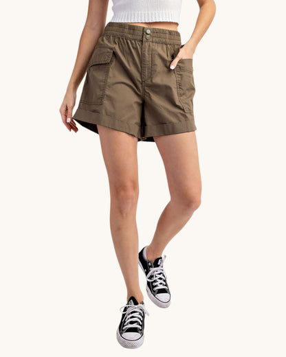 Olive cargo shorts worn by a person on a white background.