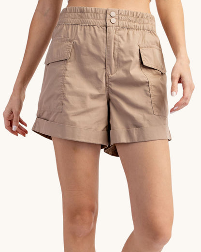 Taupe cargo shorts worn by a person on a white background.