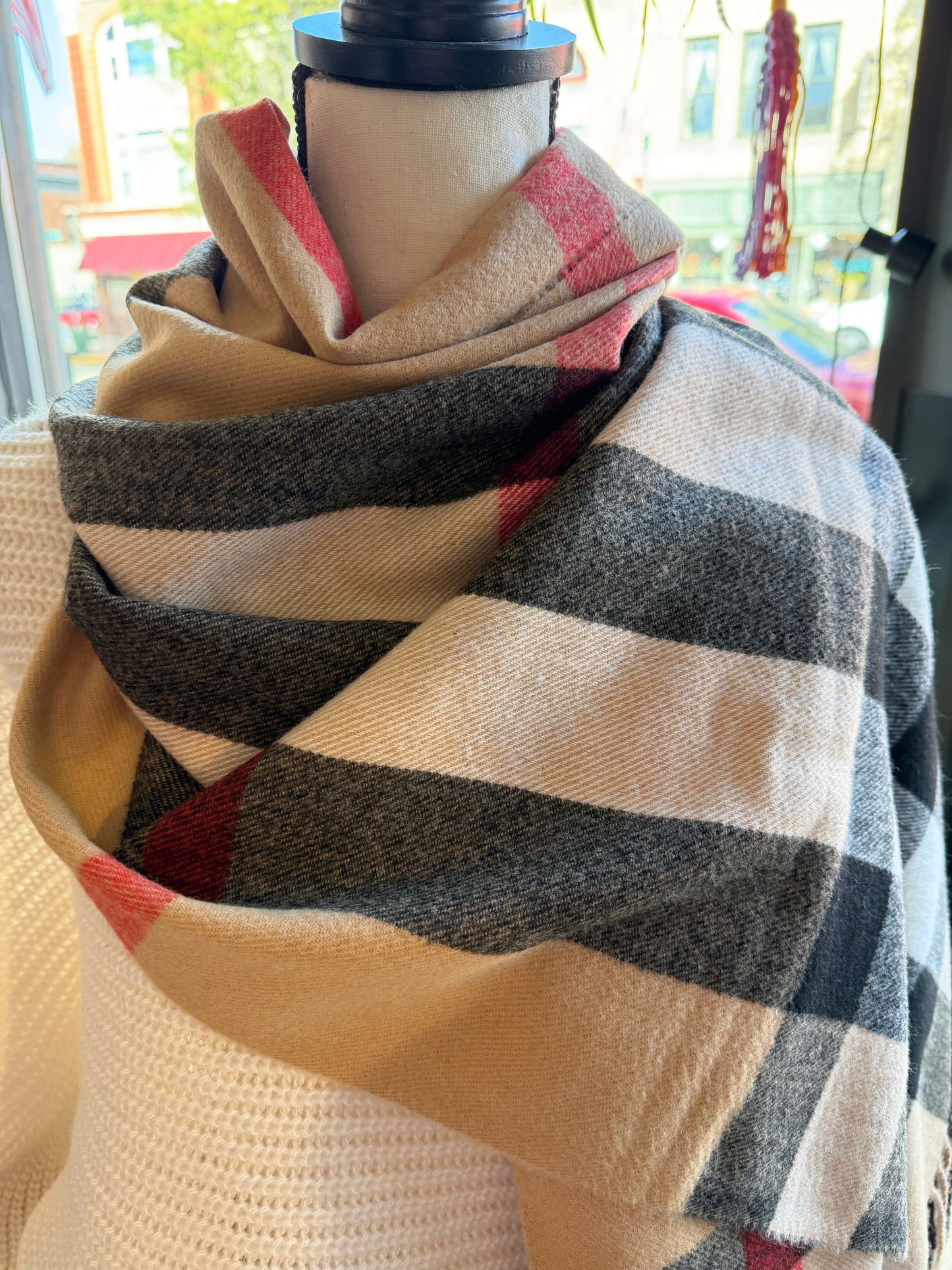 Camel, red, black and ivory plaid pattern cashmere scarf  on a mannequin. 