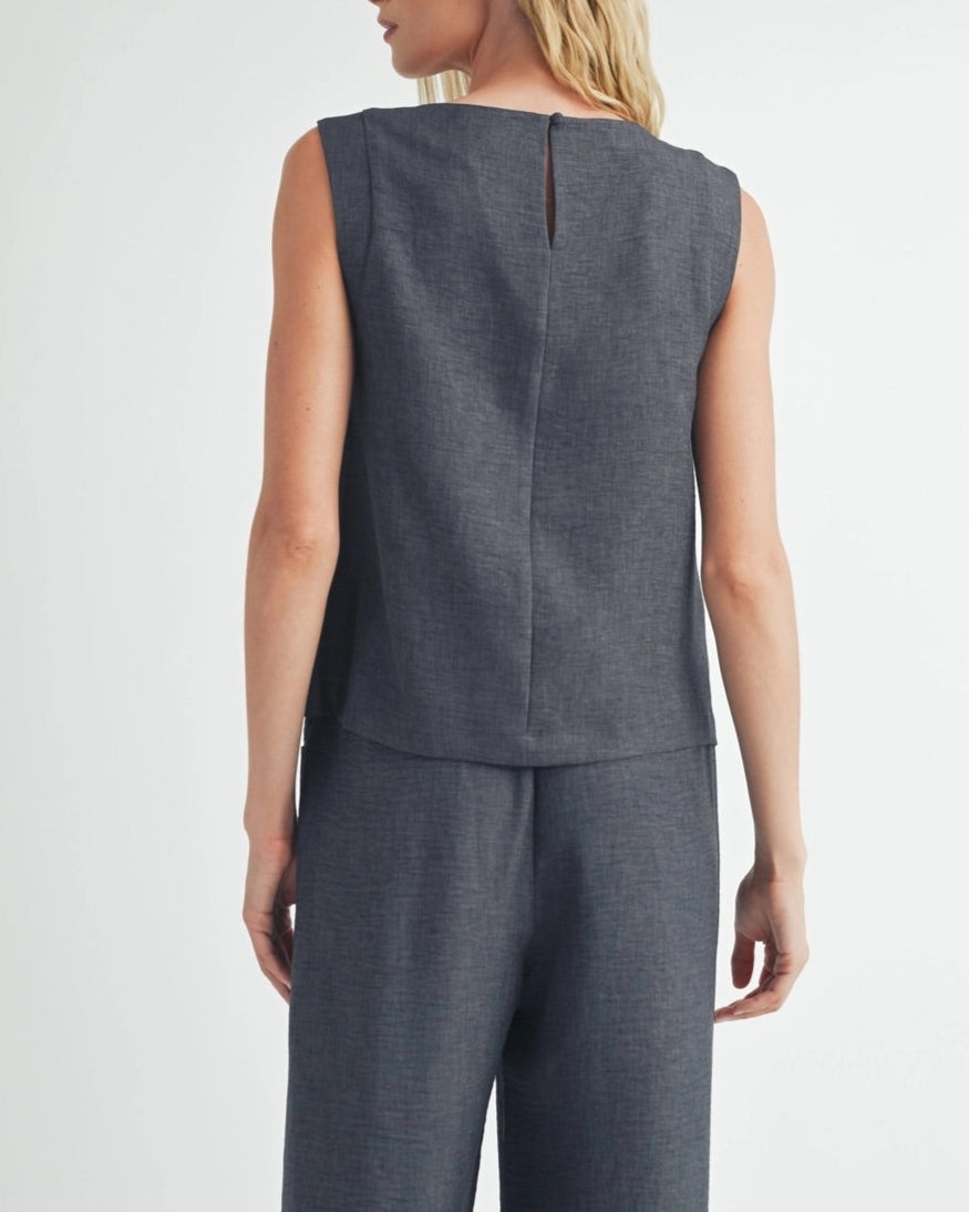 Woman wearing a dark gray sleeveless top and matching bottoms against a white background.
