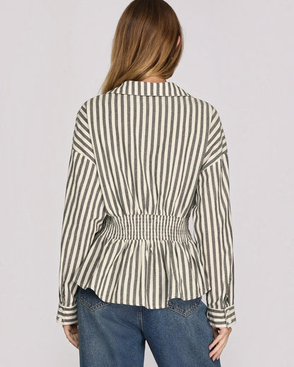 Back view of a model wearing a charcoal and white stripe button up with a smocked back. 