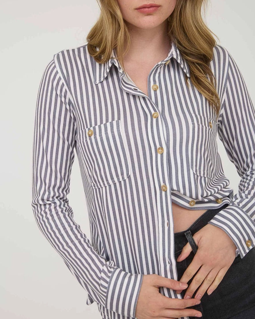 Woman wearing a striped shirt with a white background.