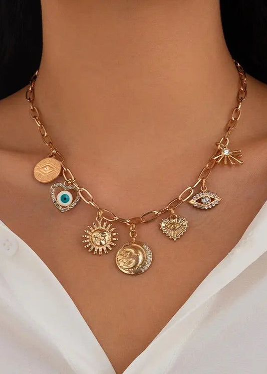 Chic, Gold-plated charm necklace with Sun, Evil Eye, Heart, and Hammered Disc charms, adjustable ball chain extension, and lobster clasp closure.