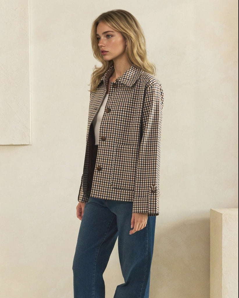 Knee up view of model wearing a brown and cream check jacket with blue wide-leg jeans.
