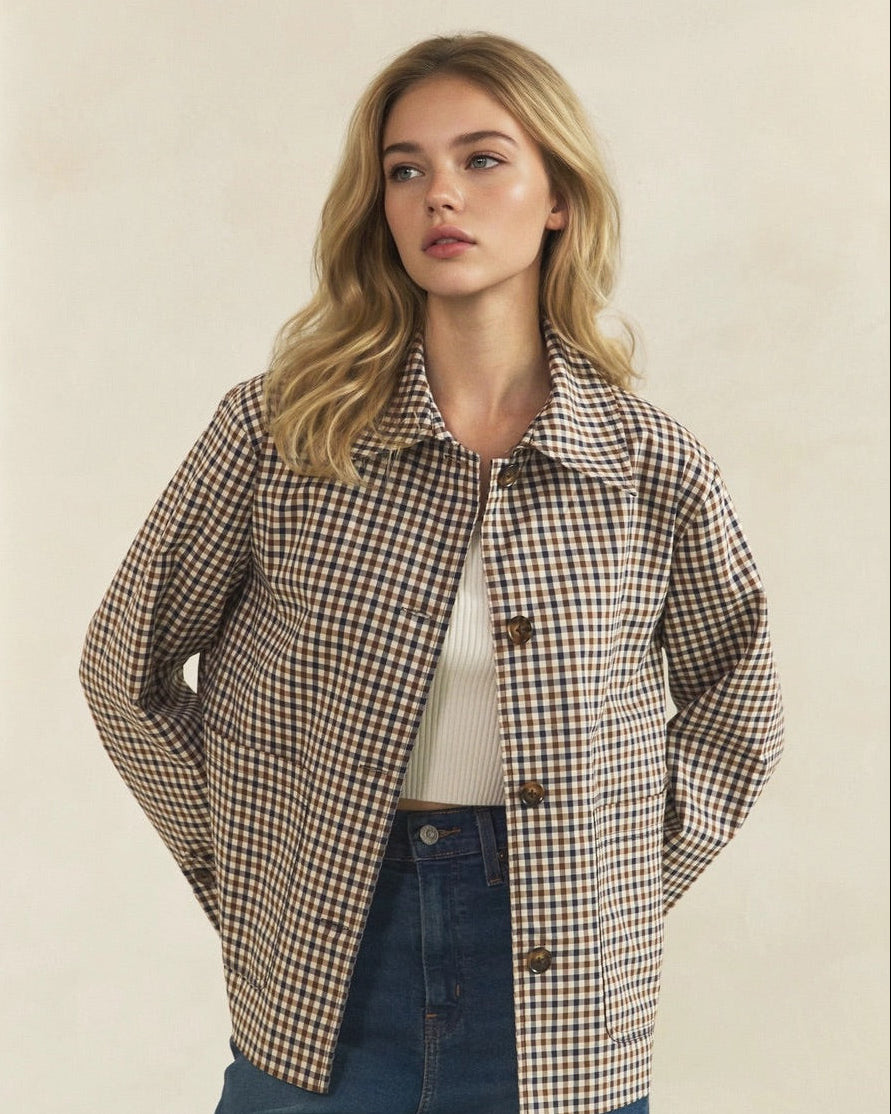 Model wearing an open brown and cream check jacket with a pointed collar and contrasting brown buttons.