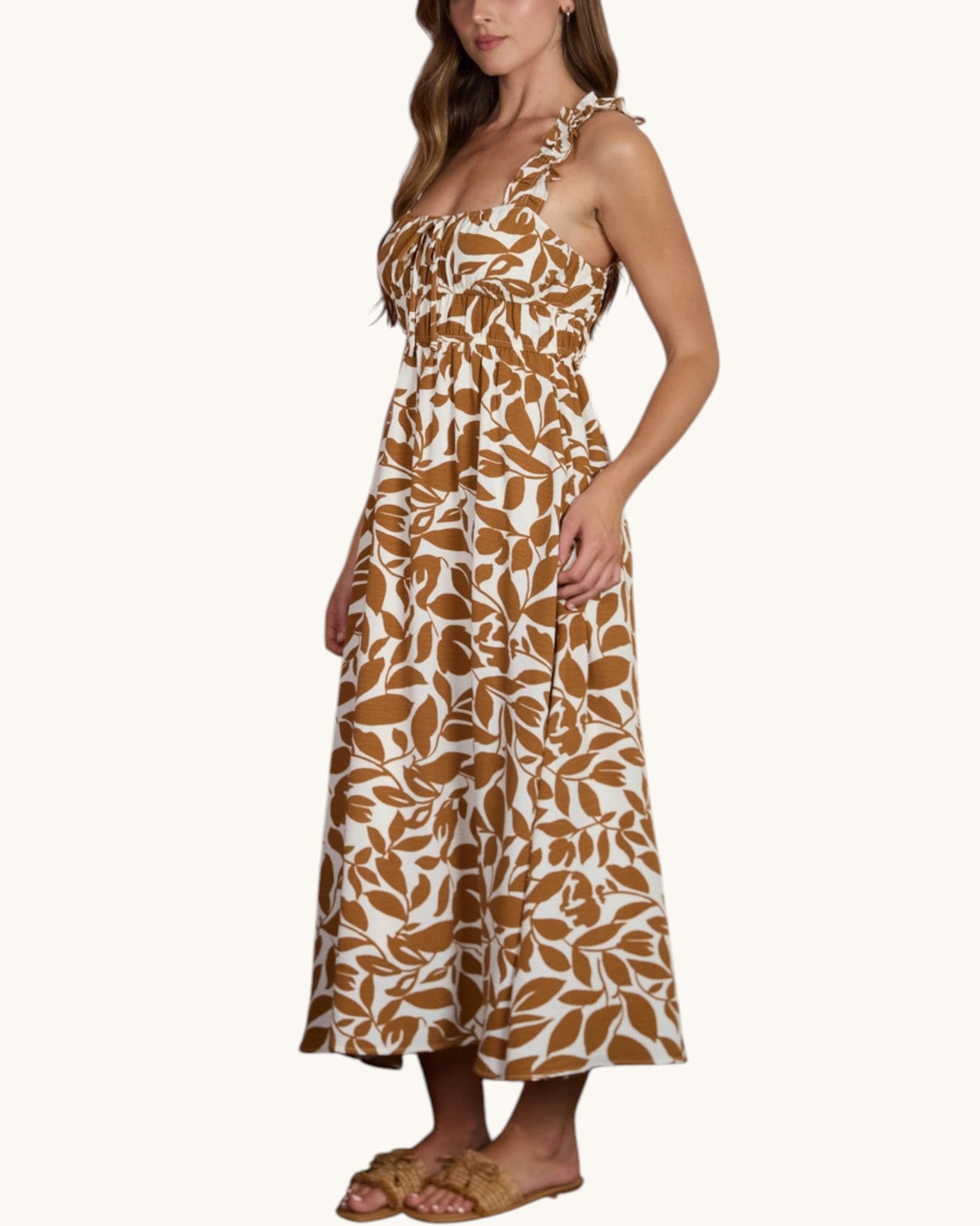Woman wearing a brown and ivory leaf print summer midi dress on a white background.