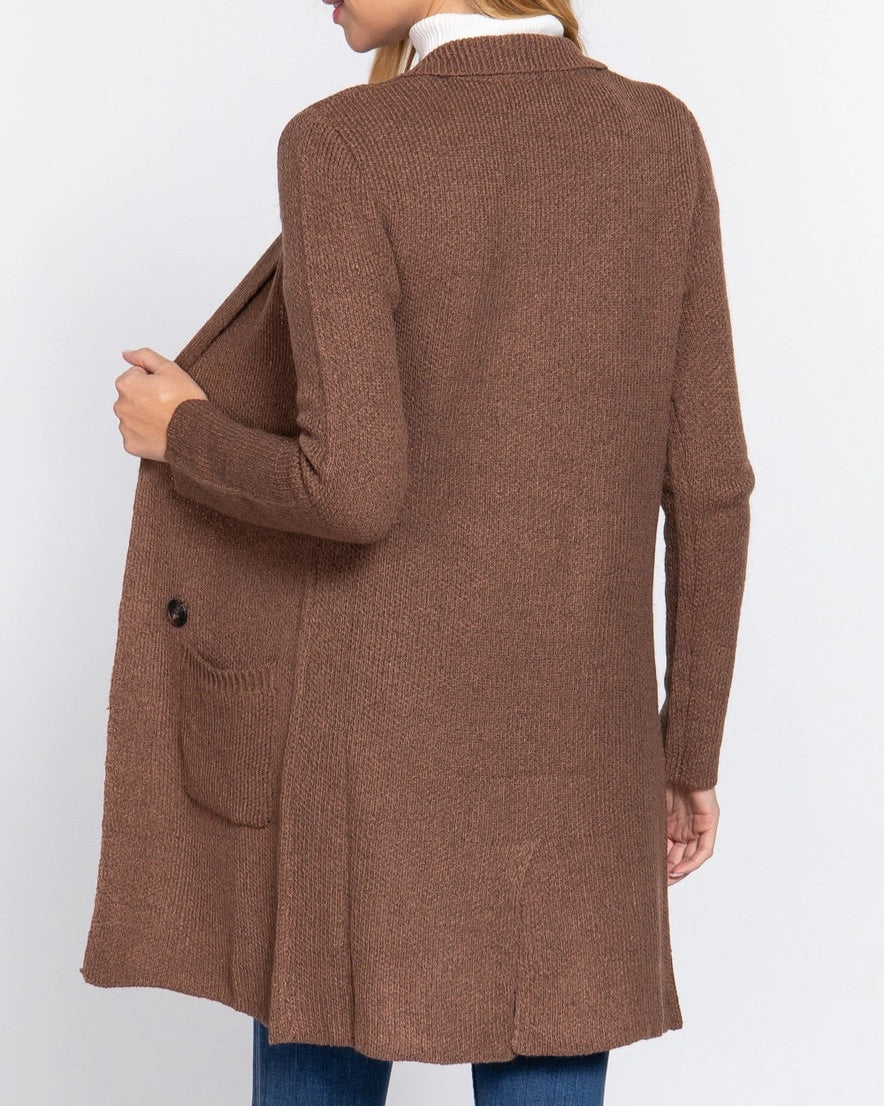 Woman wearing a brown cardigan on a white background.