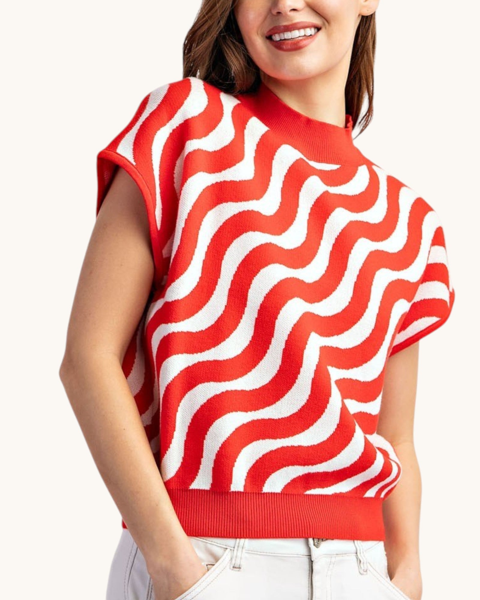 Cherry red and white swirl short sleeve summer sweater worn with white shorts, front view.