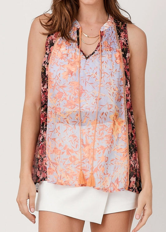 Sleeveless mixed print floral blouse with lavender and orange front and contrasting dark floral sides.