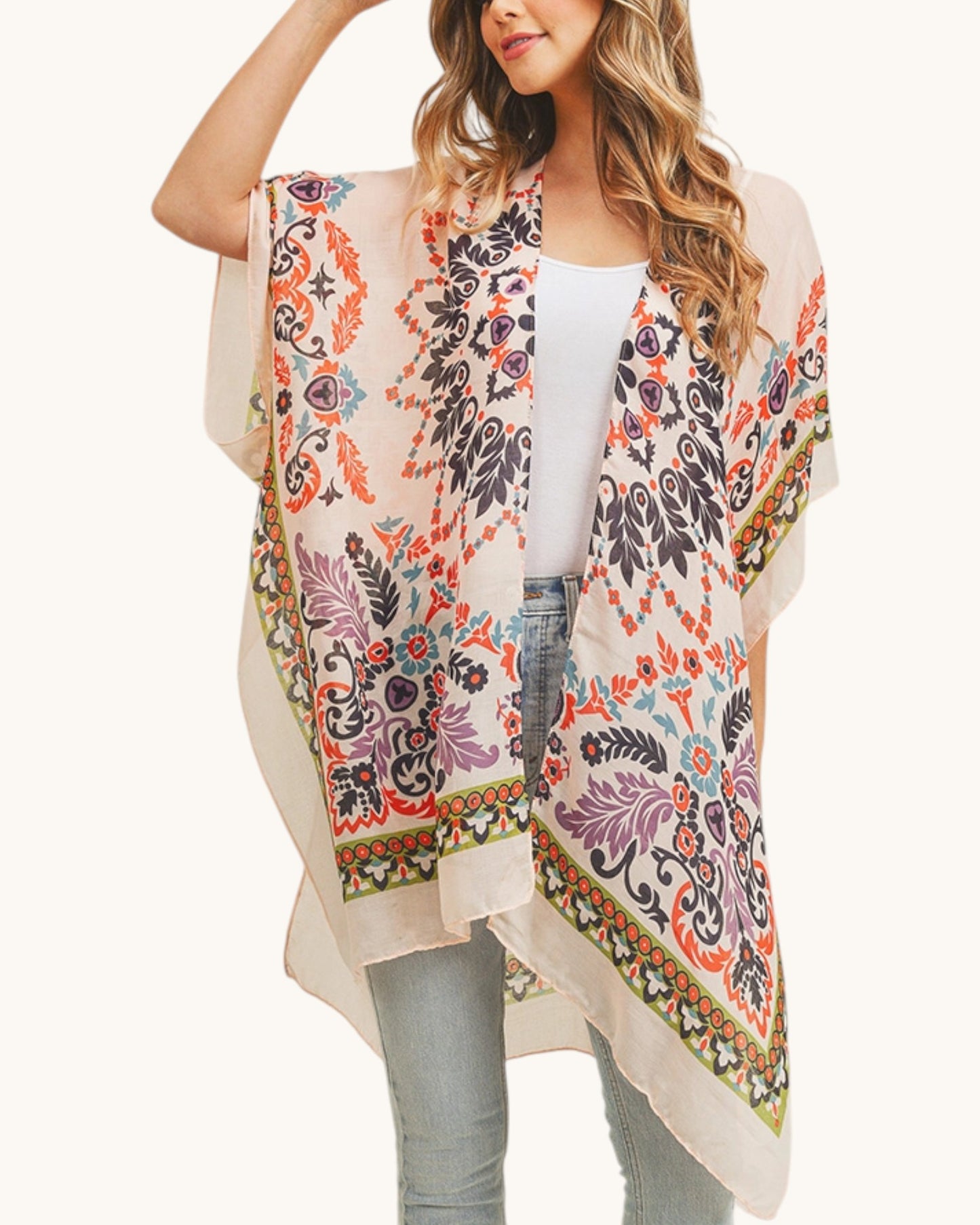 Woman wearing a colorful boho patterned kimono style wrap on a white background.