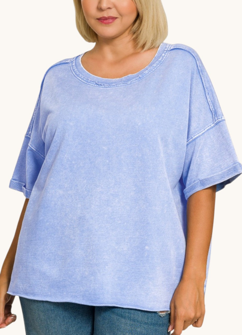 Woman wearing a light blue oversized t-shirt on a white background.