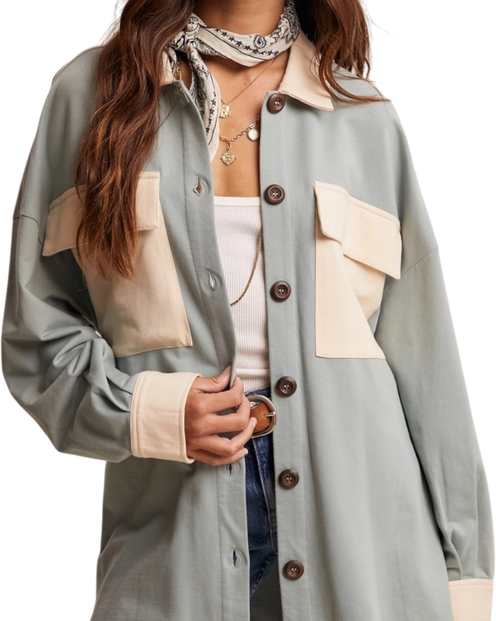 Person wearing a light sage and cream jacket with brown buttons on a white background.
