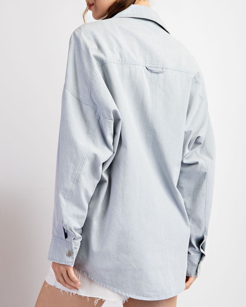 Woman wearing a light blue denim jacket / shacket.