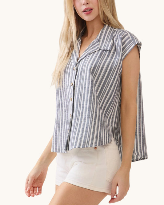 Woman wearing a sleeveless striped shirt and white shorts on a white background.