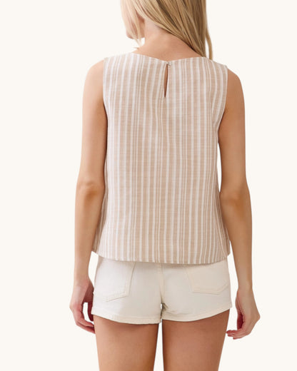 Woman wearing a beige striped sleeveless top and white shorts on a white background