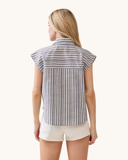 Woman wearing a striped shirt and white shorts on a white background