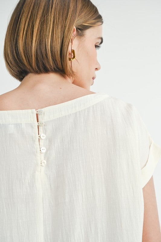Cream button back dolman sleeve top with relaxed fit.