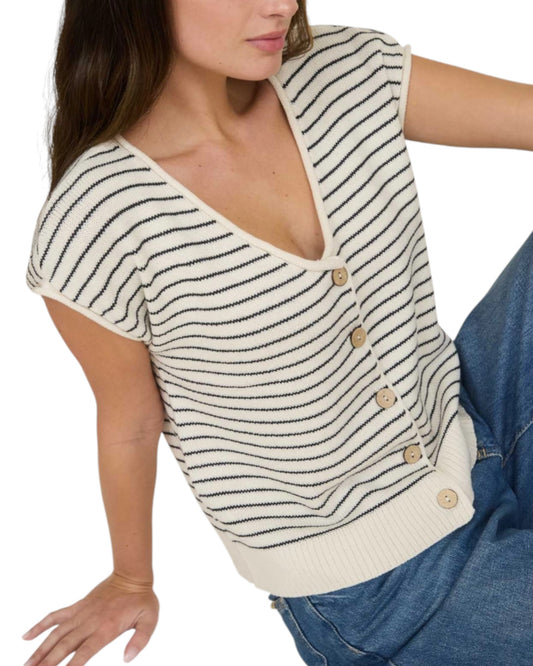 Woman wearing a Cream and Navy striped short sleeve button up cardigan.