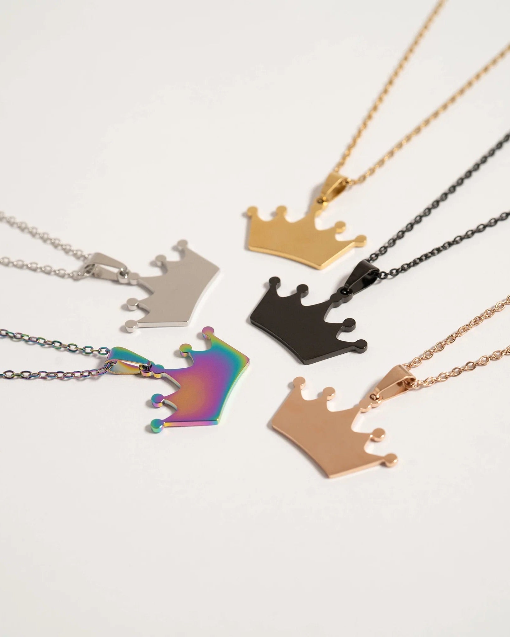 Collection of crown-shaped necklaces in various colors on a white background.