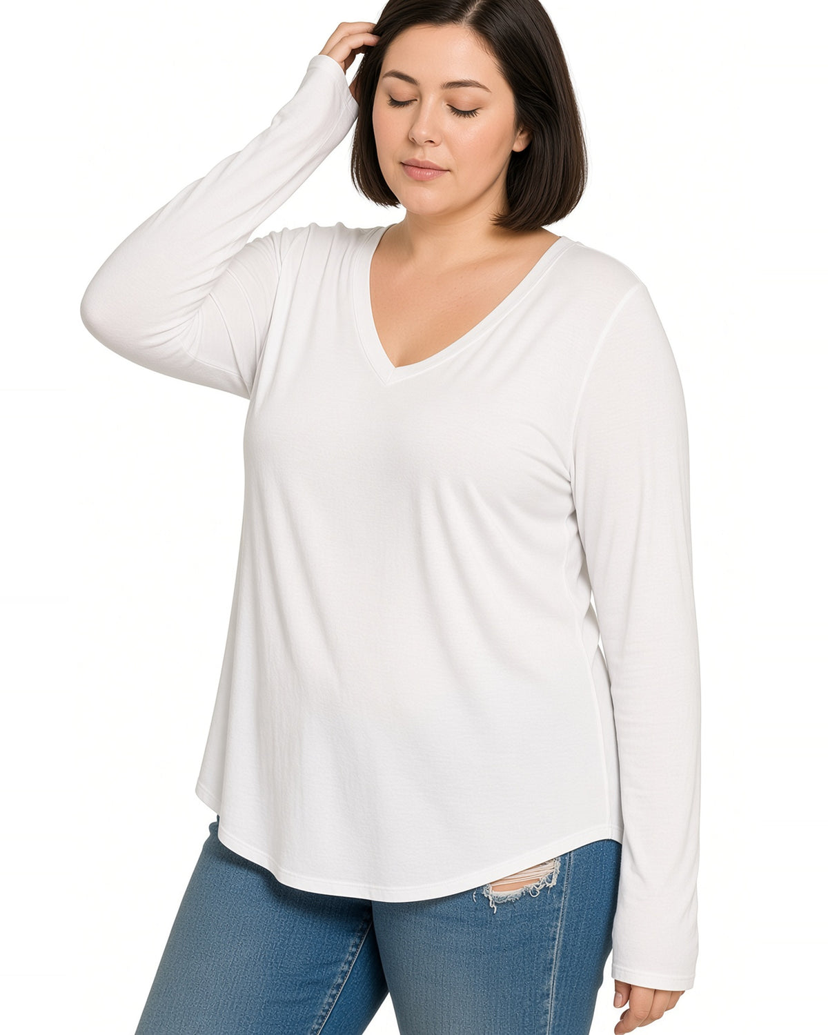 A woman wearing a white long-sleeve V-neck top and blue jeans, posing against a plain white background.
