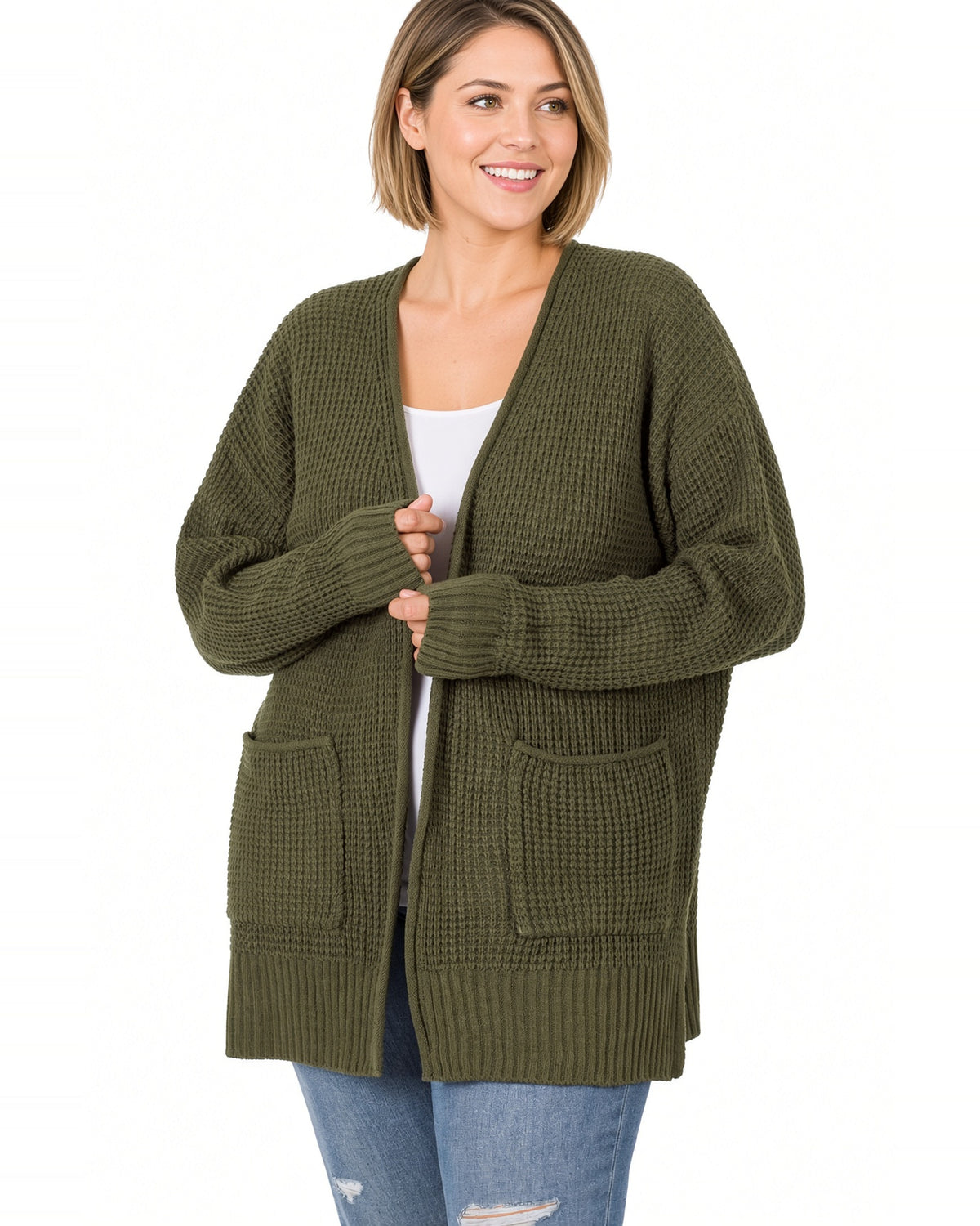 Woman wearing a dark olive waffle open cardigan with white tee shirt and blue jeans.