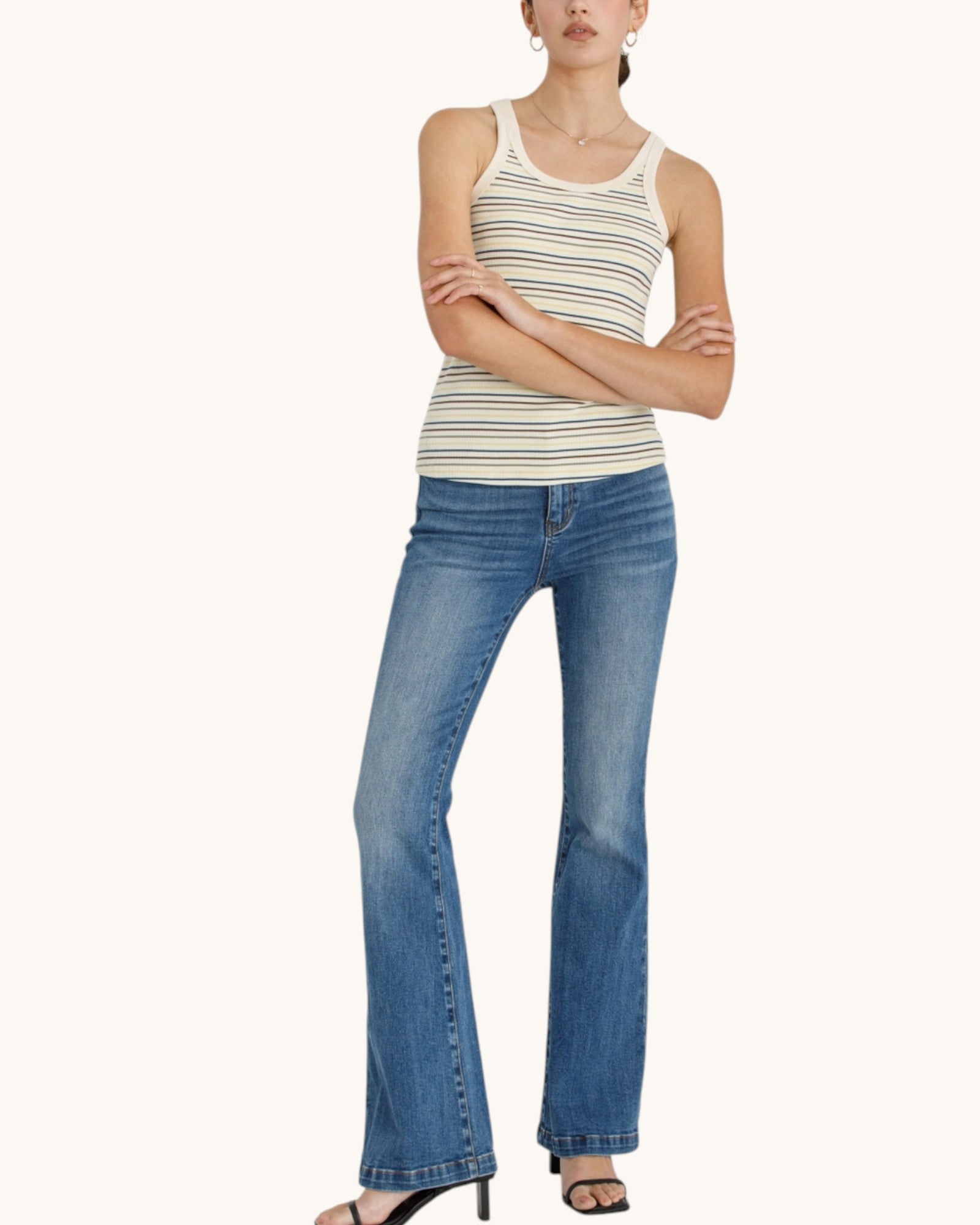Front view of the Daytrip Multi-Color Striped Ribbed Tank Top paired with a bootcut denim jean and black sandals. 