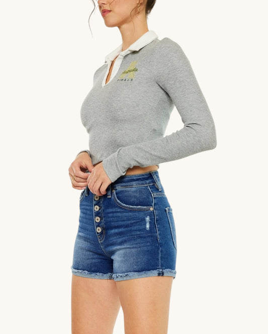 Woman wearing a gray sweater with a white collar and blue denim shorts on a white background