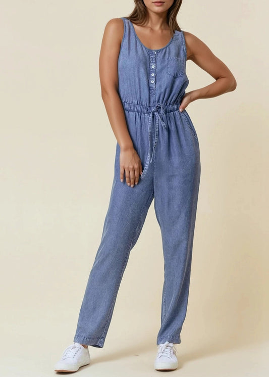 Sleeveless medium wash denim jumpsuit with scoop neck and drawstring waist.