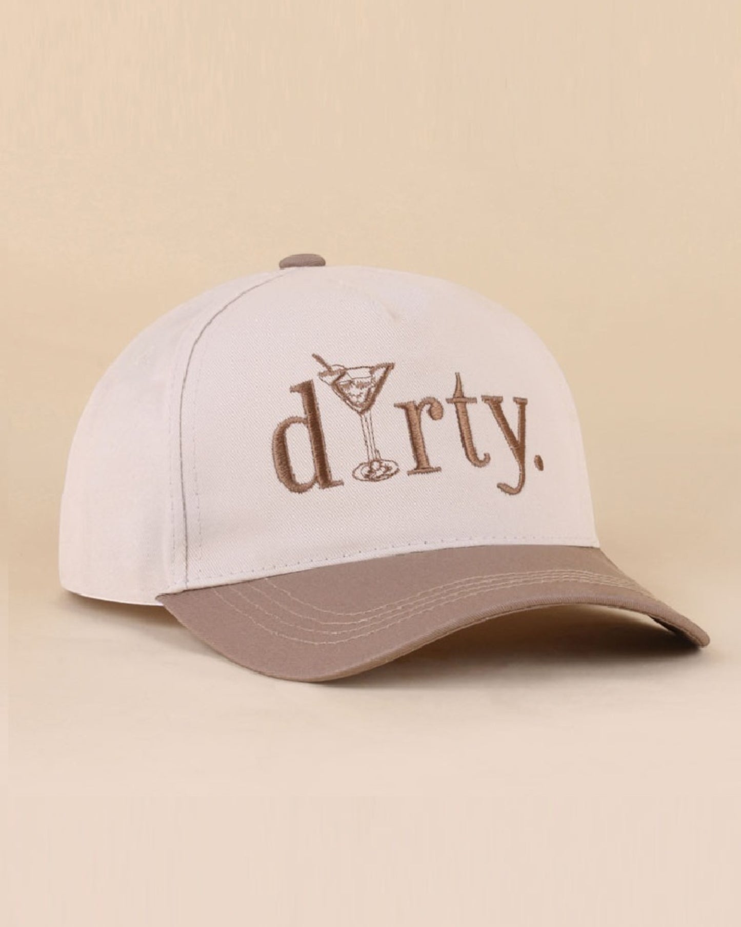 Cream cap with brown brim and 'dirty' text on a beige background.