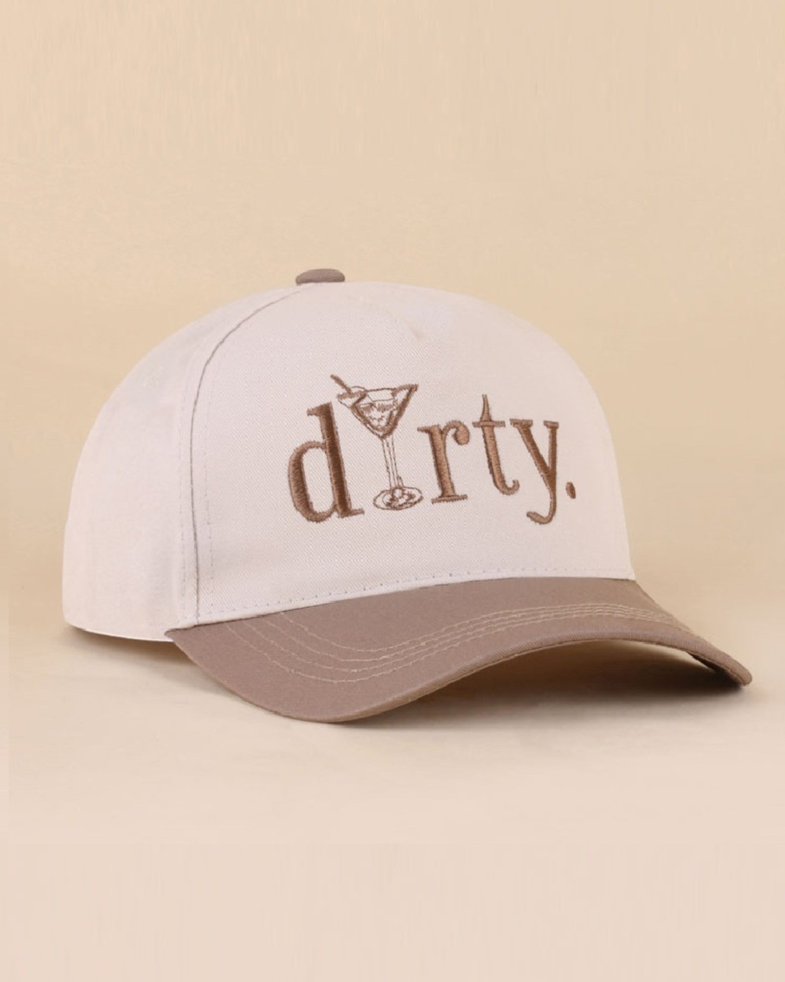 Cream cap with brown brim and 'dirty' text on a beige background.