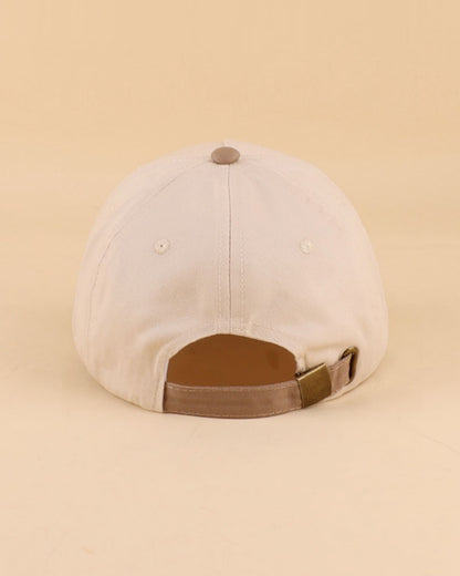 Beige cap with brown strap on a beige background.