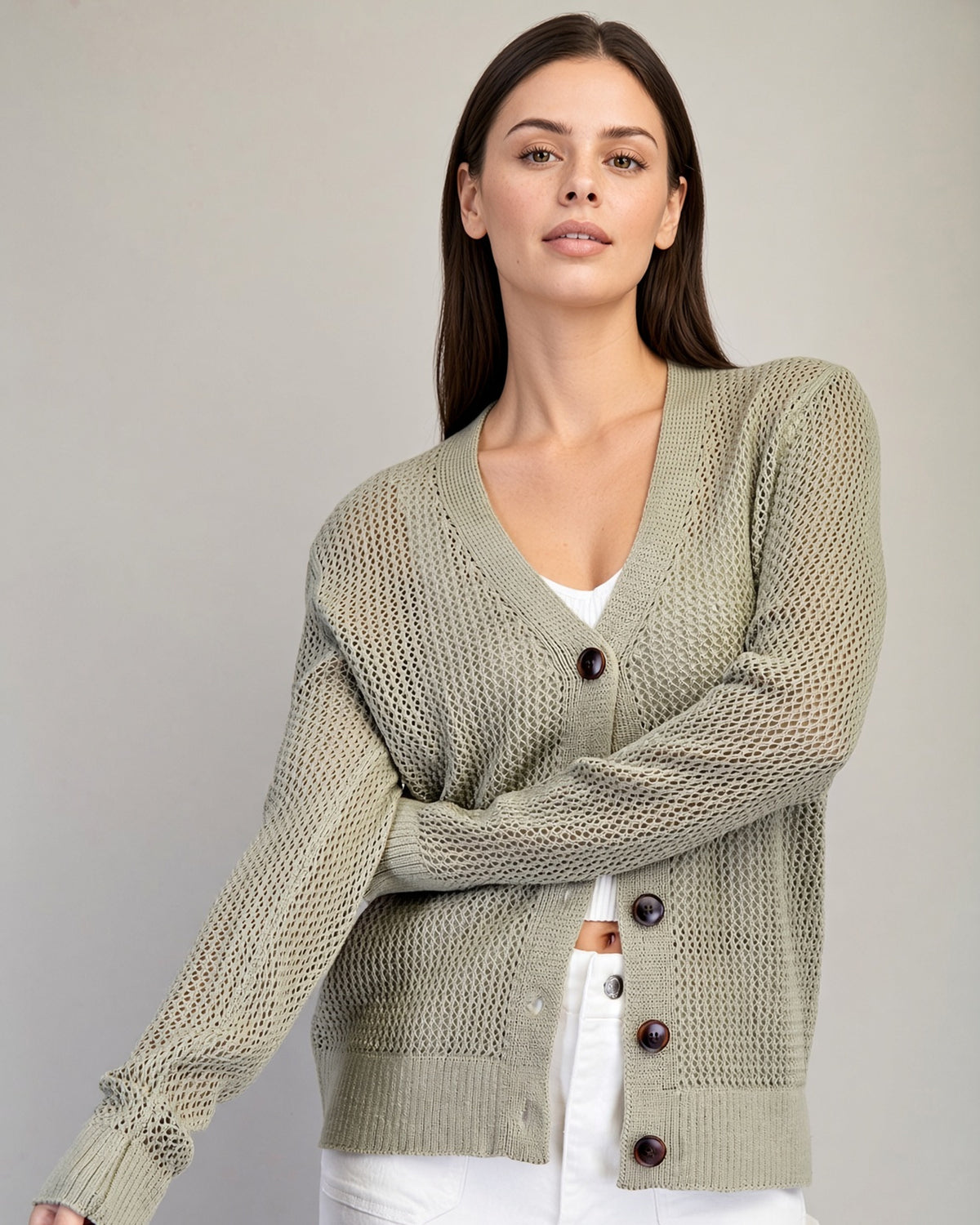 Model wearing Dry Herb cardigan with breathable open knit and oversized tortoiseshell buttons.