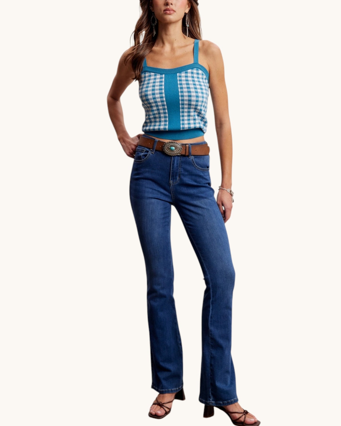 Woman wearing a blue checkered top and blue jeans on a white background.